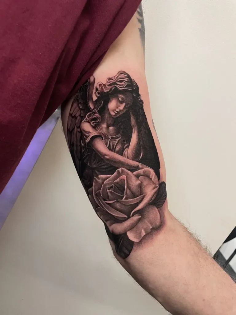 Tattoo of an angel with wings and a large rose