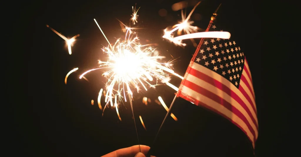 Holding a sparkler and an American flag