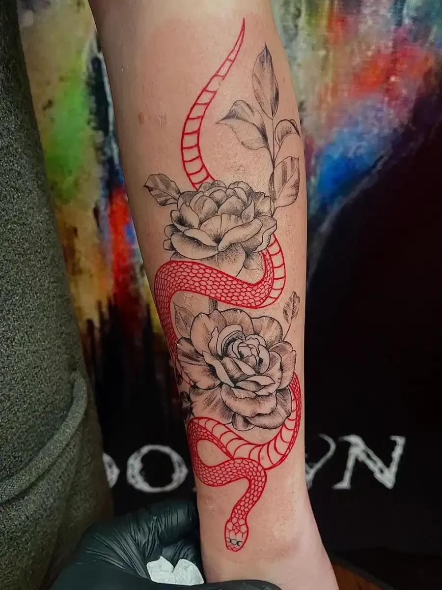 fineline tattoo of two flowers and a snake